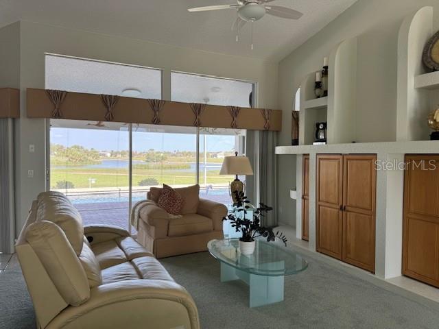507 Monaco Dr, Punta Gorda, FL 33950 - living room featuring light colored carpet, a ceiling fan, and a water view