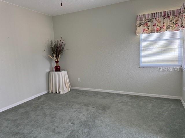 507 Monaco Dr, Punta Gorda, FL 33950 - carpeted empty room featuring baseboards and ceiling fan