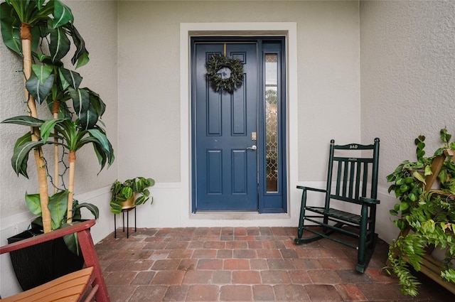 doorway to property featuring stucco siding