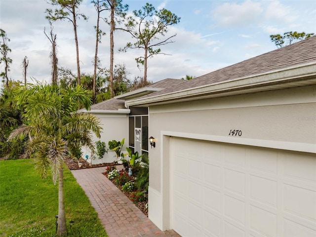 view of front of property with roof with shingles, driveway, and stucco siding