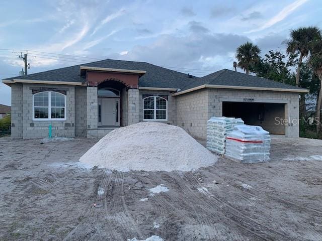 view of front of home with a garage and a shingled roof