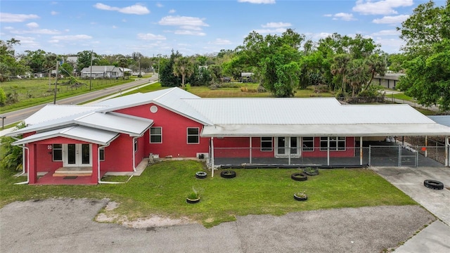 single story home with an attached carport, fence, driveway, french doors, and a front lawn