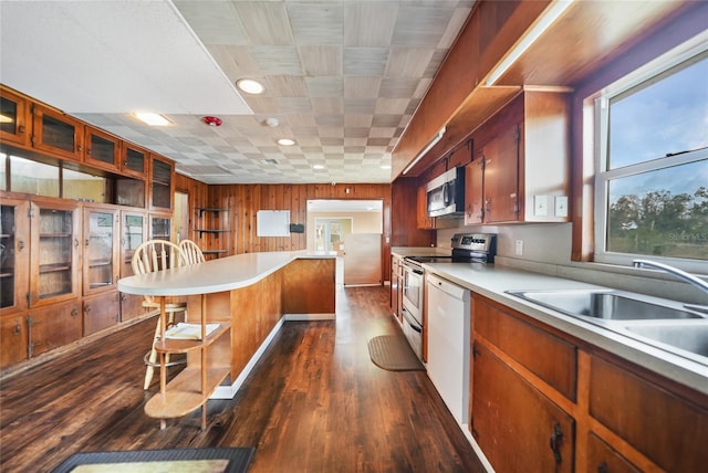 kitchen featuring a breakfast bar, appliances with stainless steel finishes, light countertops, and a sink