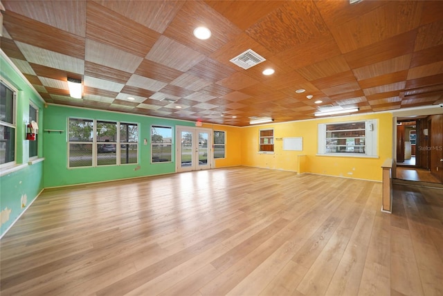 unfurnished living room with light wood-type flooring, wooden ceiling, visible vents, and french doors