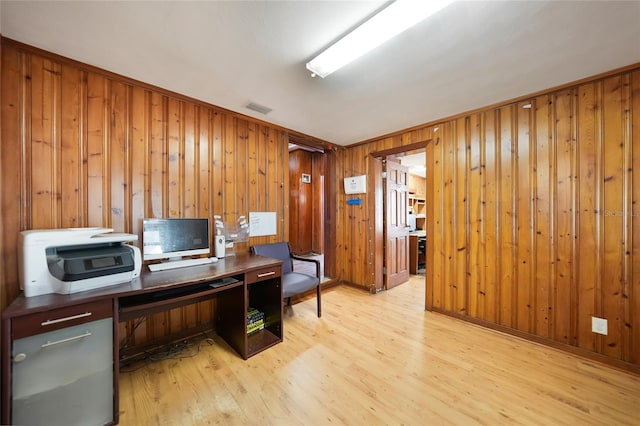 home office featuring visible vents, wooden walls, and light wood finished floors