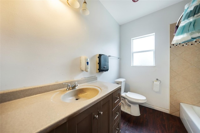 bathroom with a shower, toilet, vanity, wood finished floors, and a tub