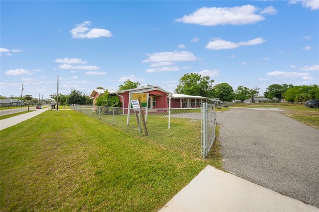 view of front facade featuring a front yard, fence, and driveway