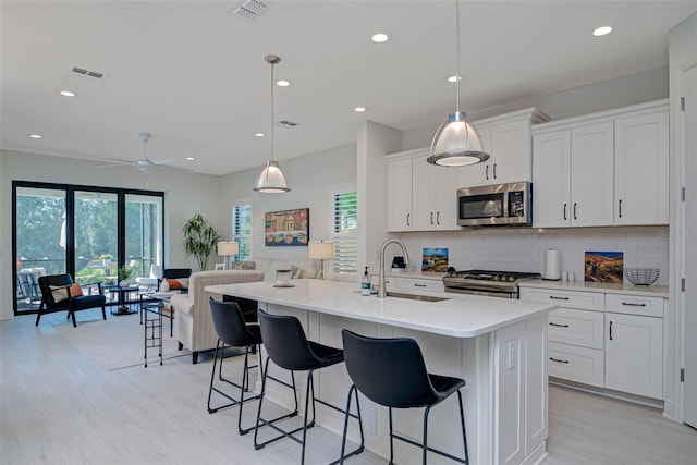 kitchen featuring plenty of natural light, visible vents, appliances with stainless steel finishes, and decorative backsplash