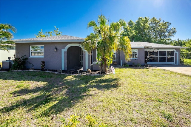 view of front of property featuring stucco siding, driveway, and a front lawn