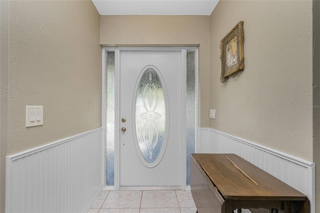 entryway featuring light tile patterned floors and wainscoting