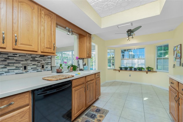 kitchen featuring tasteful backsplash, light countertops, light tile patterned floors, baseboards, and dishwasher