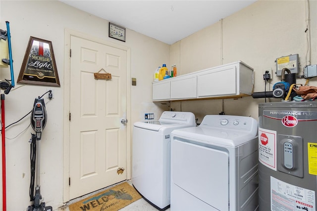 washroom featuring water heater, cabinet space, and washer and clothes dryer