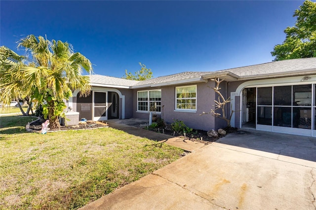 ranch-style house with a front lawn, roof with shingles, and stucco siding