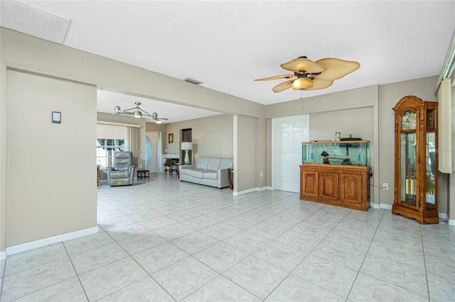 unfurnished living room featuring visible vents, baseboards, and ceiling fan