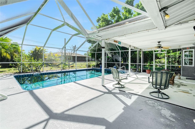 outdoor pool with glass enclosure, a patio, and ceiling fan