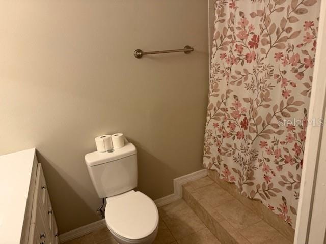 bathroom with toilet, vanity, baseboards, and tile patterned floors