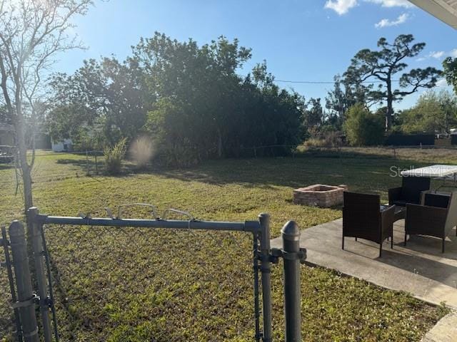 view of yard with a patio area, an outdoor fire pit, and fence