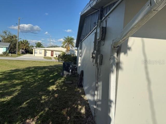 view of side of property featuring a lawn and stucco siding