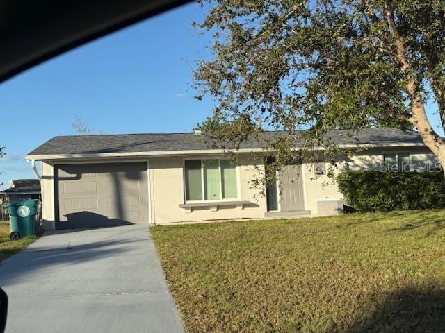 ranch-style house featuring an attached garage, a front yard, concrete driveway, and stucco siding