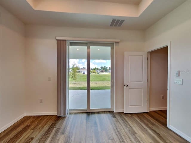 doorway to outside with visible vents, baseboards, and wood finished floors