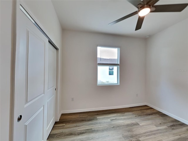 unfurnished bedroom featuring a closet, baseboards, and wood finished floors