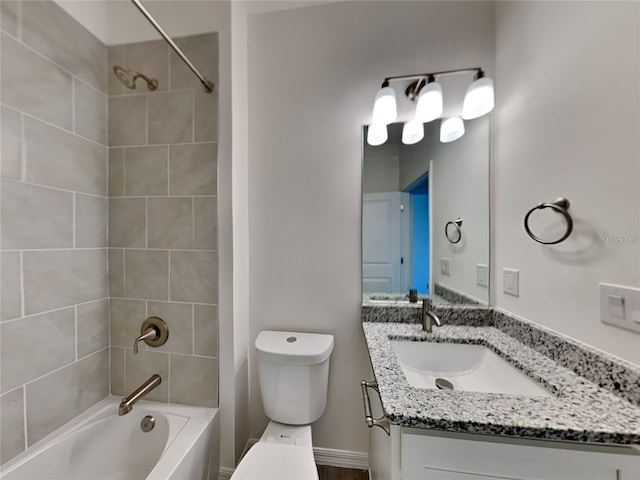 full bath with baseboards, vanity, toilet, and washtub / shower combination