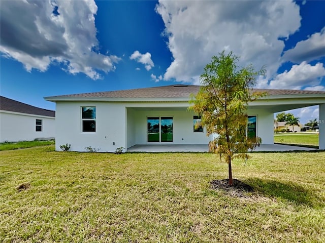 back of house featuring a yard and stucco siding