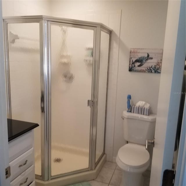 bathroom with tile patterned flooring, a shower stall, and toilet