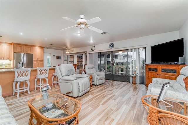 living area with ceiling fan, visible vents, and light wood-style flooring