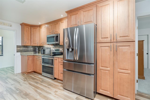 kitchen featuring recessed lighting, stainless steel appliances, backsplash, light brown cabinetry, and light wood finished floors