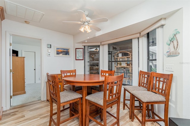 dining area with a ceiling fan, visible vents, and light wood-style floors