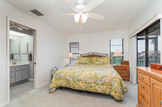 bedroom featuring light carpet, a sink, a ceiling fan, visible vents, and baseboards