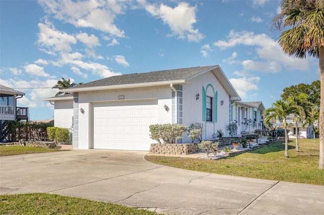 view of front of home featuring driveway, a garage, a front lawn, and stucco siding