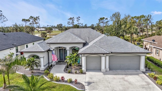 french provincial home featuring concrete driveway, a shingled roof, an attached garage, and stucco siding