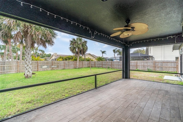 unfurnished sunroom with plenty of natural light and ceiling fan