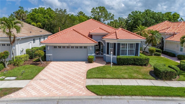 mediterranean / spanish home featuring a tiled roof, decorative driveway, an attached garage, and stucco siding