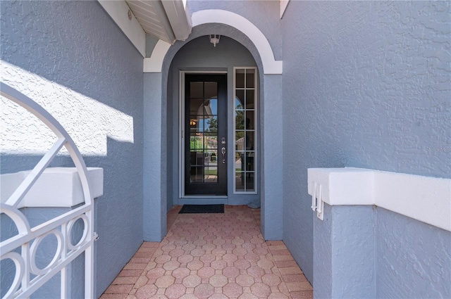 entrance to property featuring stucco siding