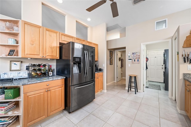 kitchen with stone counters, light tile patterned floors, open shelves, visible vents, and refrigerator with ice dispenser