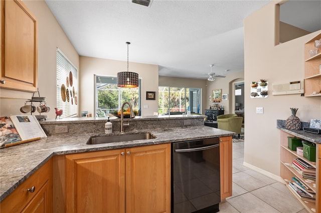 kitchen with arched walkways, a peninsula, a sink, dishwasher, and dark stone countertops