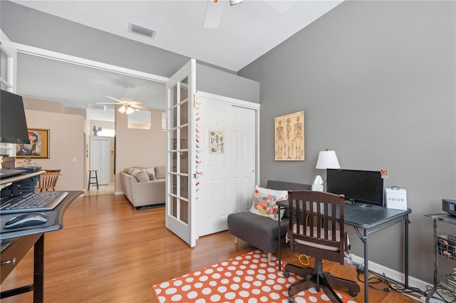 office featuring wood finished floors, visible vents, a ceiling fan, baseboards, and french doors