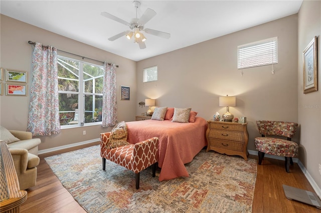 bedroom featuring a ceiling fan, baseboards, and wood finished floors