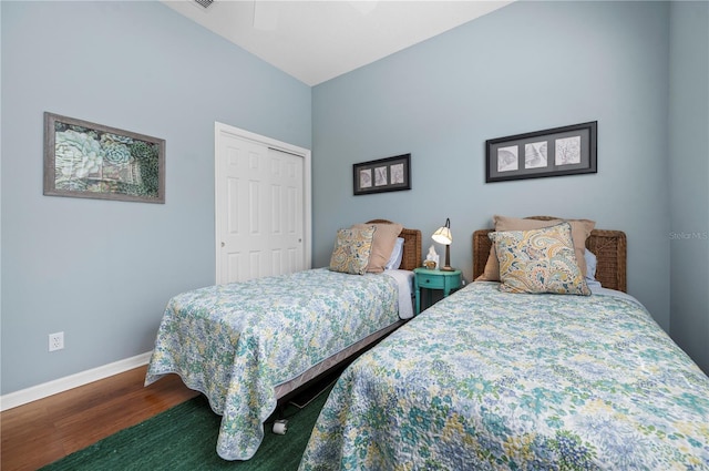 bedroom with ceiling fan, a closet, baseboards, and wood finished floors