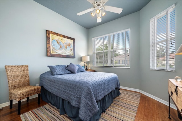 bedroom with multiple windows, baseboards, and wood finished floors