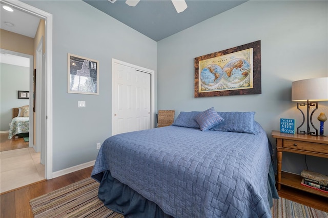 bedroom with a ceiling fan, a closet, baseboards, and wood finished floors