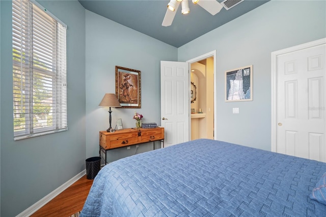 bedroom featuring a ceiling fan, visible vents, baseboards, and wood finished floors