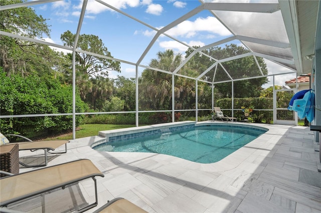 outdoor pool featuring glass enclosure and a patio