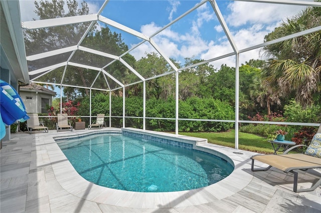 outdoor pool with a lanai and a patio area