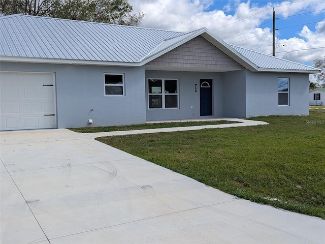 ranch-style house with a garage, a front yard, metal roof, and stucco siding