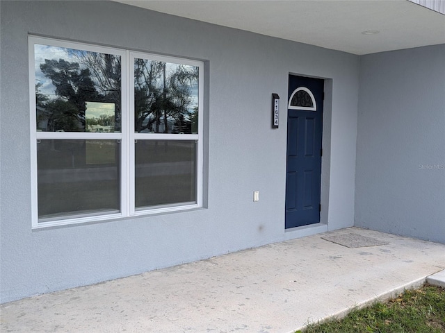 property entrance with stucco siding