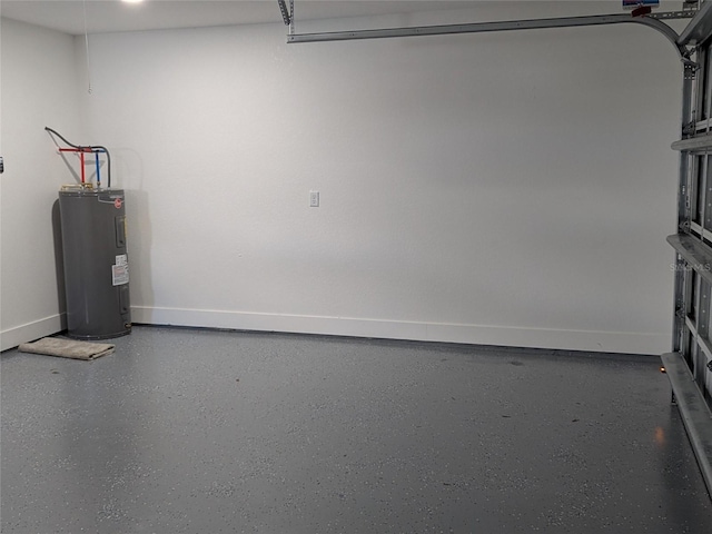 garage featuring baseboards and electric water heater